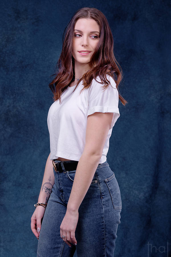 Portrait photo féminin sur fond peint bleu jean